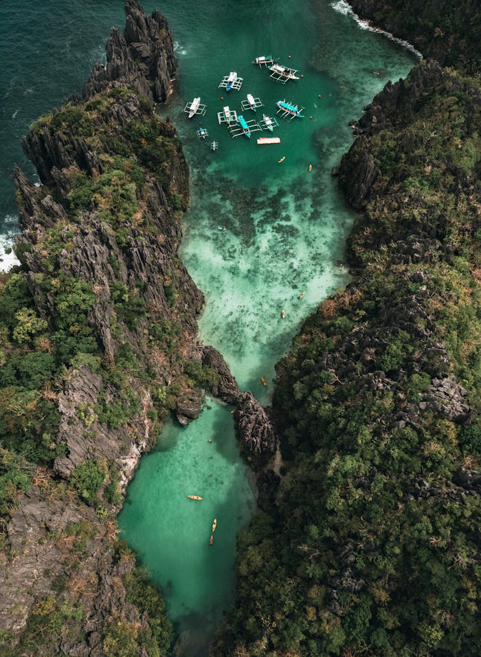 Mastering the First Impression: Your intriguing post title goes here Stunning aerial view of boats in a turquoise lagoon surrounded by cliffs in El Nido, Philippines.